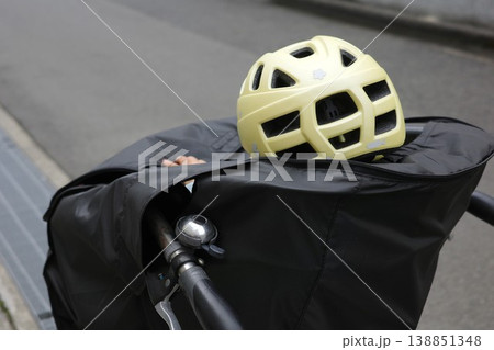 子供乗せ自転車の前かごにヘルメットを被り乗る子供 138851348