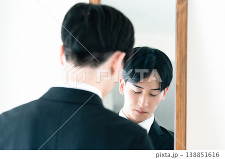 鏡の前で身だしなみを整えるスーツ姿の男性 鏡の前で身だしなみを整えるスーツ姿の男性 138851616
