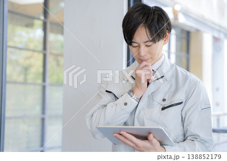 タブレットを持って考える作業員の男性 タブレットを持って考える作業員の男性 138852179
