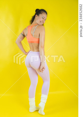 Woman posing in activewear against yellow background 138852682