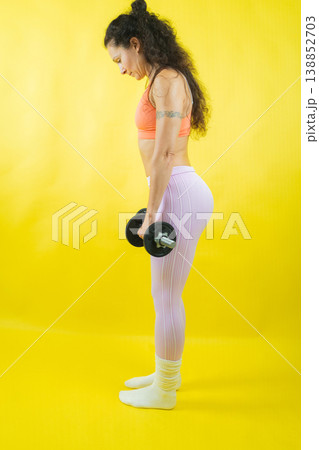 Woman holding dumbbell preparing for strength training workout Woman holding dumbbell preparing for strength training workout 138852703