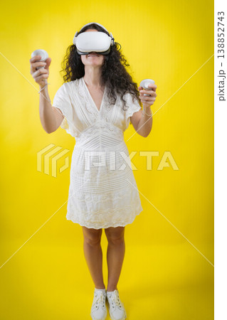 Woman experiencing virtual reality wearing headset and controllers Woman experiencing virtual reality wearing headset and controllers 138852743
