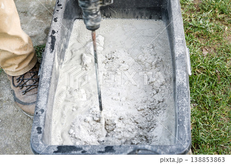 Mixing cement in a container for construction work at a job site on a clear day 138853863