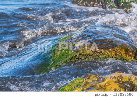 Sea water splashing over the stones on the beach 138855590