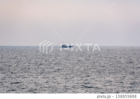 Fishing boat in blue sea and clear sky with birds flying overhead. 138855608