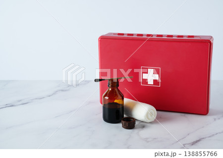 Iodine bottle, bandage, and first aid kit on table. Medical supplies for wound care, hygiene, and emergency treatment concept. 138855766