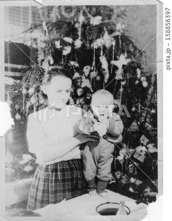 Grandmother holding baby near decorated new year tree 1950s Grandmother holding baby near decorated new year tree 1950s 138856397