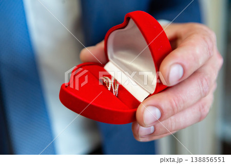 wedding rings in hand. wedding rings in the hands of the groom. wedding rings in hand. wedding rings in the hands of the groom. 138856551