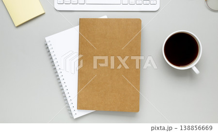 Simple desk arrangement with coffee cup, eyeglasses and notebook forming quiet concentrated work setting 138856669
