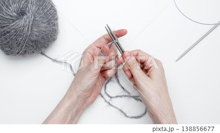 Woman knitting with needles using gray yarn creating warm handmade clothing 138856677