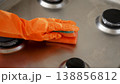 Woman cleaning gas stove with sponge in kitchen after washing 138856812
