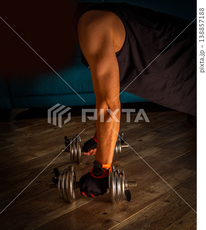 Man doing home workout with dumbbells 138857188
