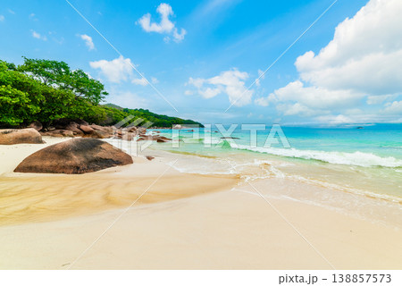 White sand and rocks in a tropical beach on a sunny day White sand and rocks in a tropical beach on a sunny day 138857573