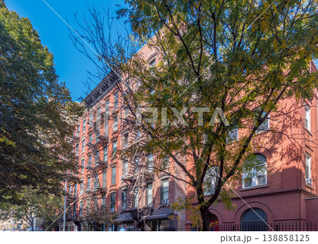 Green trees and orange buildings in a narrow street in Greenwich Village in Manhattan 138858125