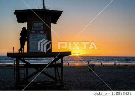 Girl on a lifeguard tower at sunset 138858425