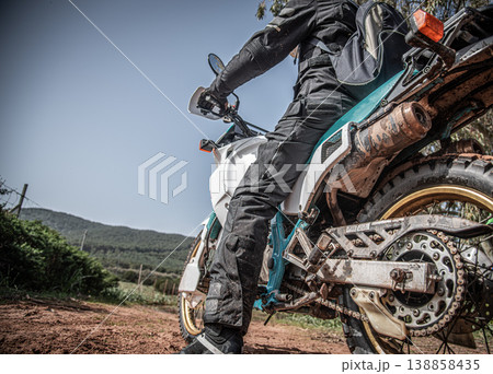 Rider and adventure bike on a dirt path Rider and adventure bike on a dirt path 138858435