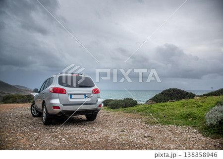 SUV Parked on Dirt Road by the Coast during Stormy Sea SUV Parked on Dirt Road by the Coast during Stormy Sea 138858946
