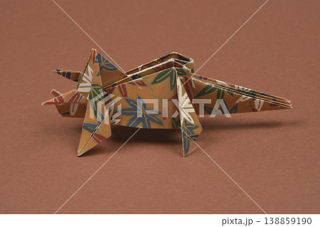 Handmade floral origami triceratops on brown background 138859190