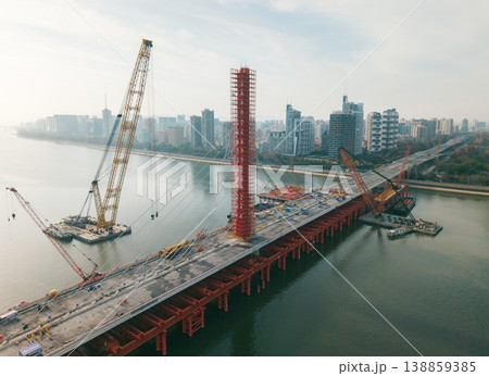Aerial view of cranes and construction equipment are working to dismantle an old cable stayed bridge. 138859385