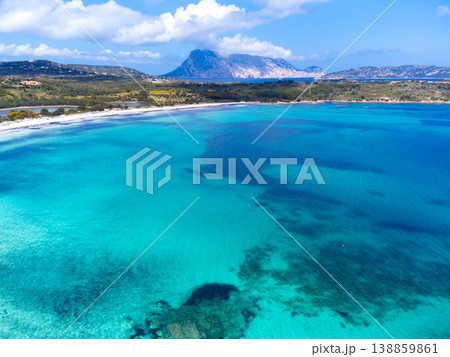 Aerial view of turquoise water shades at Lu Impostu beach with Tavolara island in background Aerial view of turquoise water shades at Lu Impostu beach with Tavolara island in background 138859861