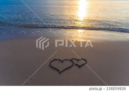 Two hearts drawn in the sand on the beach Two hearts drawn in the sand on the beach 138859926