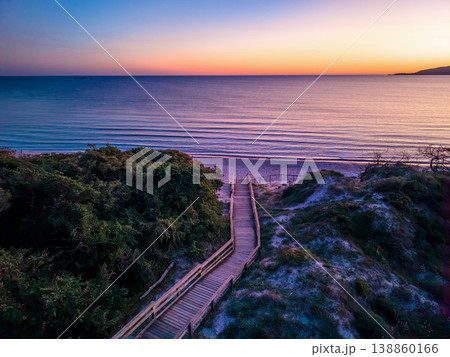 Aerial view of a wooden boardwalk leading through coastal dunes to Maria Pia beach 138860166