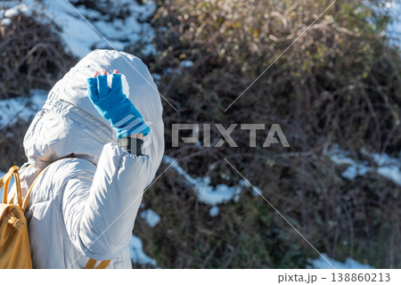 Close-Up of Woman in Winter Clothes Holding a Snowball Seen from Behind Close-Up of Woman in Winter Clothes Holding a Snowball Seen from Behind 138860213