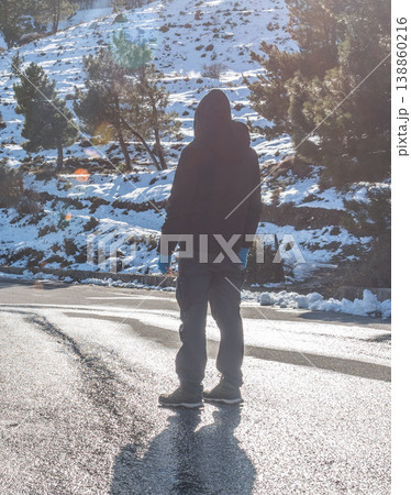 Man Standing Alone Facing Snowy Mountain Landscape in Winter Man Standing Alone Facing Snowy Mountain Landscape in Winter 138860216