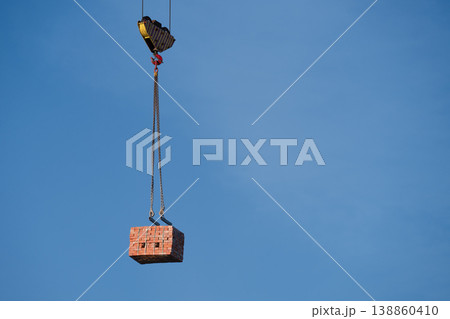 Crane Lifting Stack of Bricks Against Blue Sky . Copy space Crane Lifting Stack of Bricks Against Blue Sky . Copy space 138860410