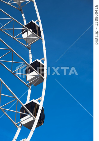 Vertical shot of a Ferris wheel cabin under the clear blue sky .  Copy space 138860416
