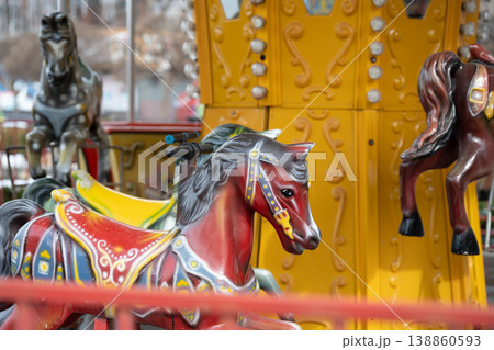 Vintage style carousel with colorful painted horses in an amusement park. Vintage style carousel with colorful painted horses in an amusement park. 138860593