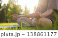Young woman practices yoga meditation outdoors in park during golden hour. Girl closeup sits in lotus pose green grass sunset. Female lotus position. Healthy lifestyle harmony wellness deep relaxation 138861177