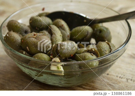 Marinated green cracked olives in glass bowl 138861186
