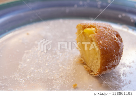 Custard filled doughnut half with sugar on a white plate 138861192