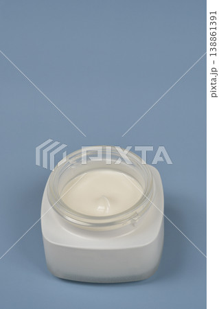 Top view of open white face cream jar on blue background Top view of open white face cream jar on blue background 138861391