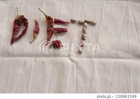 Diet word spelled with chili peppers and beans on linen Diet word spelled with chili peppers and beans on linen 138861599