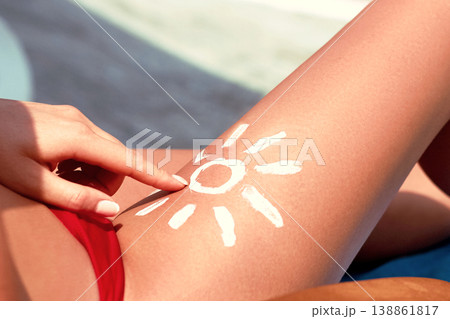 Closeup  female  leg with sun shape. Sun protection. Sun cream, on her smooth tanned legs. 138861817