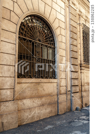 Old building wall with patterned window bars on a quiet street in the city Old building wall with patterned window bars on a quiet street in the city 138862285