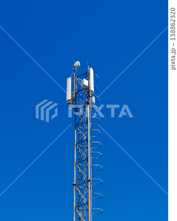 Tall telecommunication cell tower antenna mast against dark blue sky for mobile network signal transmission Tall telecommunication cell tower antenna mast against dark blue sky for mobile network signal transmission 138862320