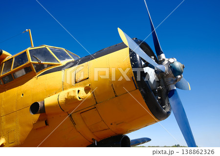 Classic yellow vintage AN-2 biplane aircraft with radial engine on airfield against blue sky at airshow Classic yellow vintage AN-2 biplane aircraft with radial engine on airfield against blue sky at airshow 138862326