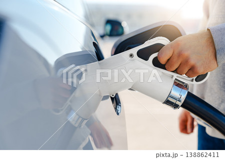 Charging an electric car at a public station during daylight hours 138862411
