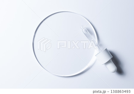 A glass circle on a blue background. A template for placing samples of cosmetics or medical products or food. A glass circle on a blue background. A template for placing samples of cosmetics or medical products or food. 138863493