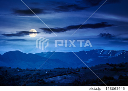 mountainous countryside scenery at night. mysterious sky above the distant valley and ridge. full moon over remote meadows and trees on rolling hills. beautiful nature landscape during spring mountainous countryside scenery at night. mysterious sky above the distant valley and ridge. full moon over remote meadows and trees on rolling hills. beautiful nature landscape during spring 138863646