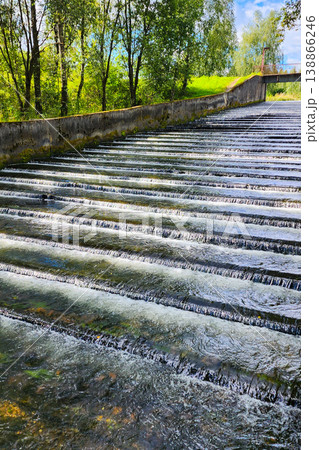 Water flowing over stepped river weir in nature Water flowing over stepped river weir in nature 138866246