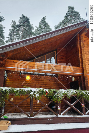 Log cabin exterior in winter with snow falling 138866269