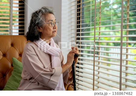 A senior citizen gazes out the window, reflecting on aging and retirement. The loneliness of Alzheimer and depression highlights the importance of compassionate elderly care and support A senior citizen gazes out the window, reflecting on aging and retirement. The loneliness of Alzheimer and depression highlights the importance of compassionate elderly care and support 138867482
