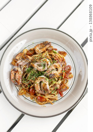 shrimp and tomato diavolo spicy spaghetti on white table at outdoor restaurant in italy shrimp and tomato diavolo spicy spaghetti on white table at outdoor restaurant in italy 138868109