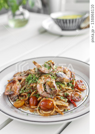 shrimp and tomato diavolo spicy spaghetti on white table at outdoor restaurant in italy 138868110