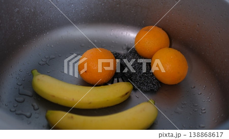 Washing fruits in kitchen sink bananas oranges cleaning fresh produce closeup home kitchen Washing fruits in kitchen sink bananas oranges cleaning fresh produce closeup home kitchen 138868617