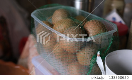Kiwi fruits in plastic mesh box closeup table fresh fruit packaging storage produce Kiwi fruits in plastic mesh box closeup table fresh fruit packaging storage produce 138868620